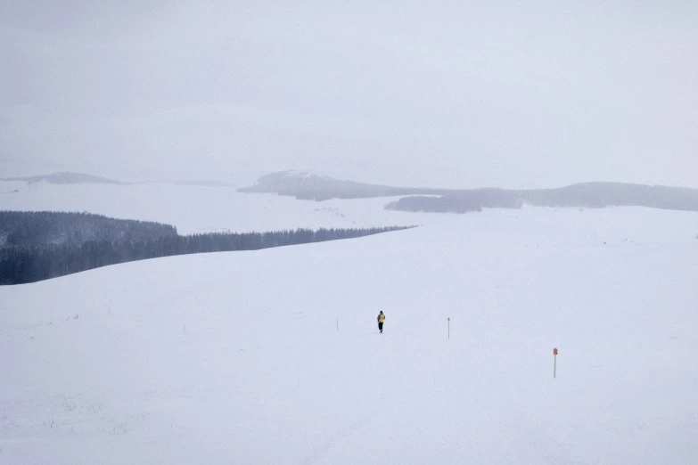 two people walking across a snow covered field