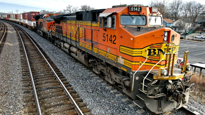 an orange and yellow train is on the railroad tracks