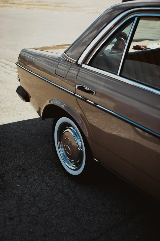 a brown car parked on a street with it's door open