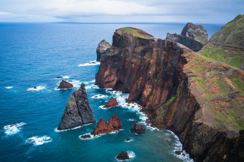 large cliffs extending into the ocean on a cloudy day