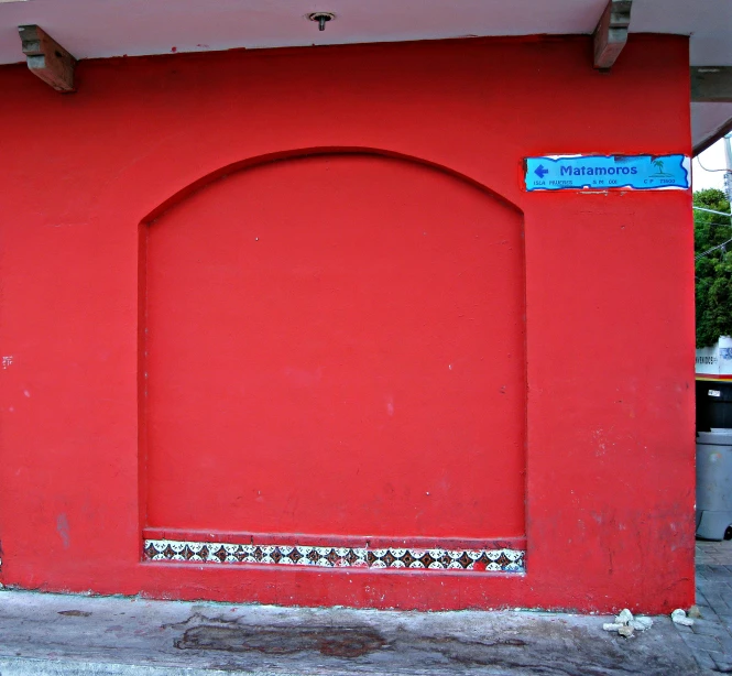 a very bright red building is painted with a mural