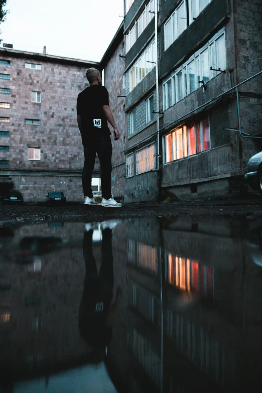 a man stands outside by a flooded pool