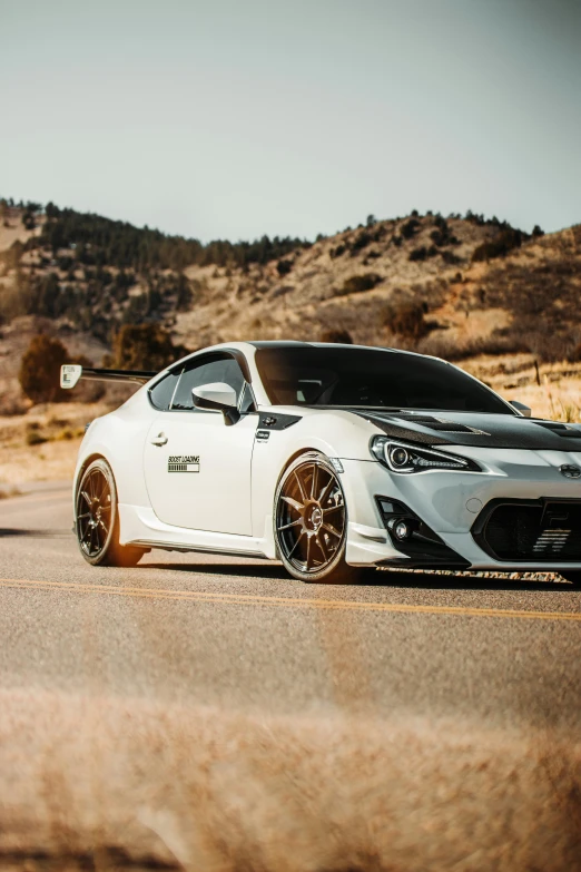 the scion, in white with black accents, is parked near a parking lot