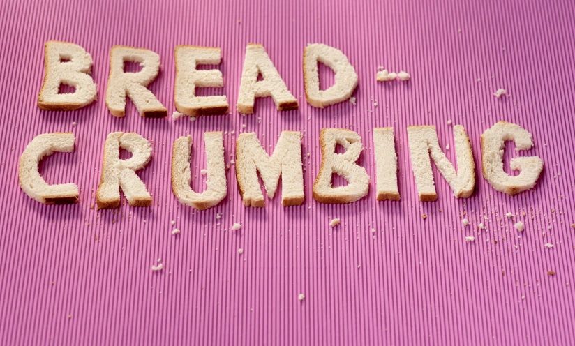word spelling on purple mat with bread crumbs placed below