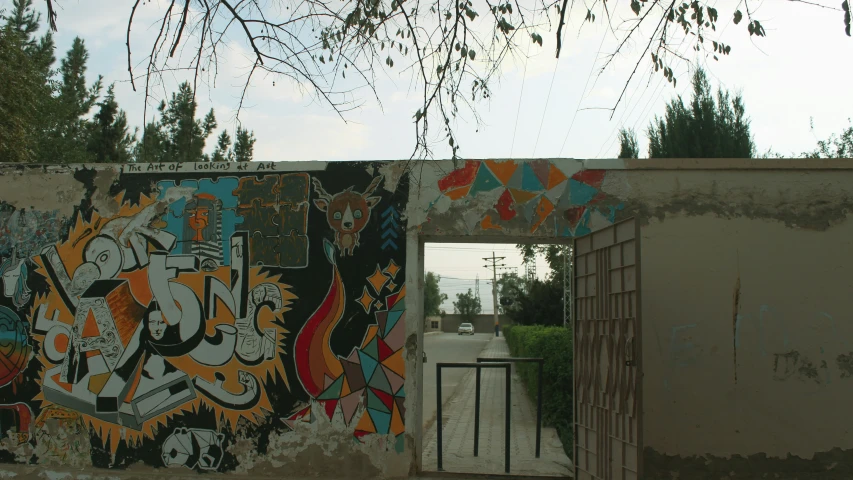 a gate that is in between two walls with graffiti on it