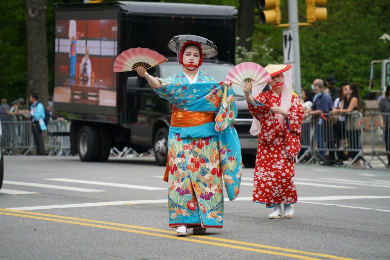 two woman dressed in traditional chinese costume perform a dance