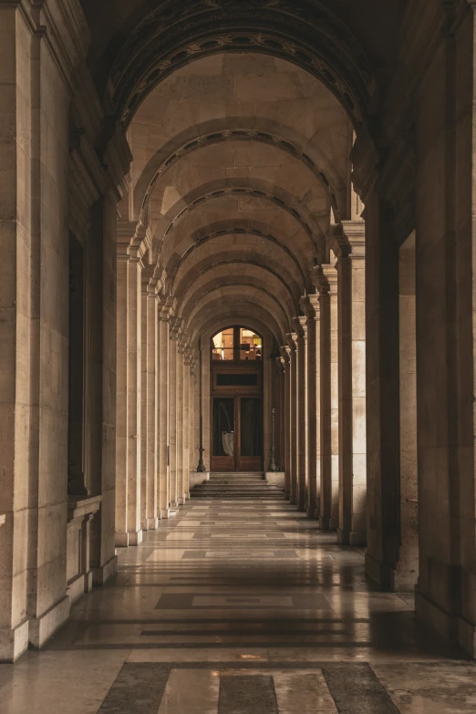 this is a long hallway with columns and a clock