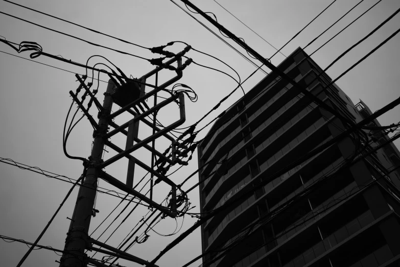 a building next to telephone wires, with power lines in front