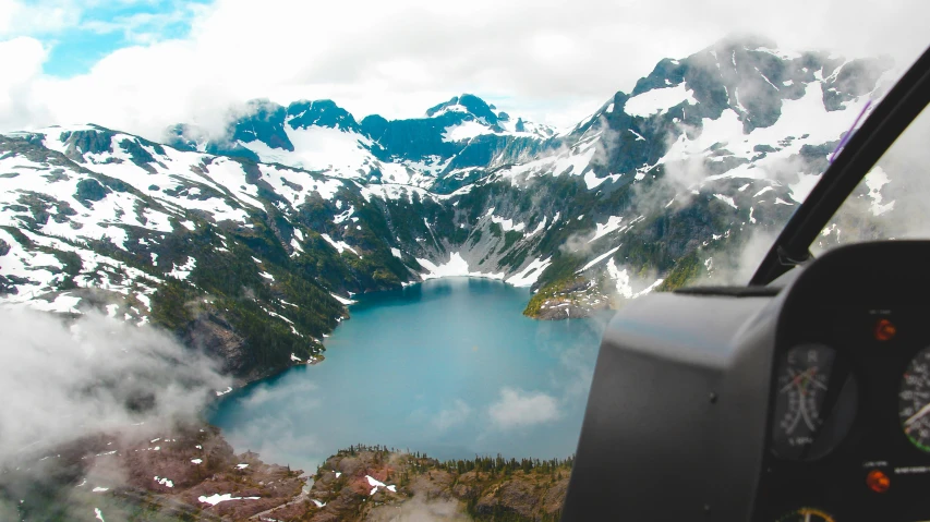 view of an alpine lake surrounded by snow