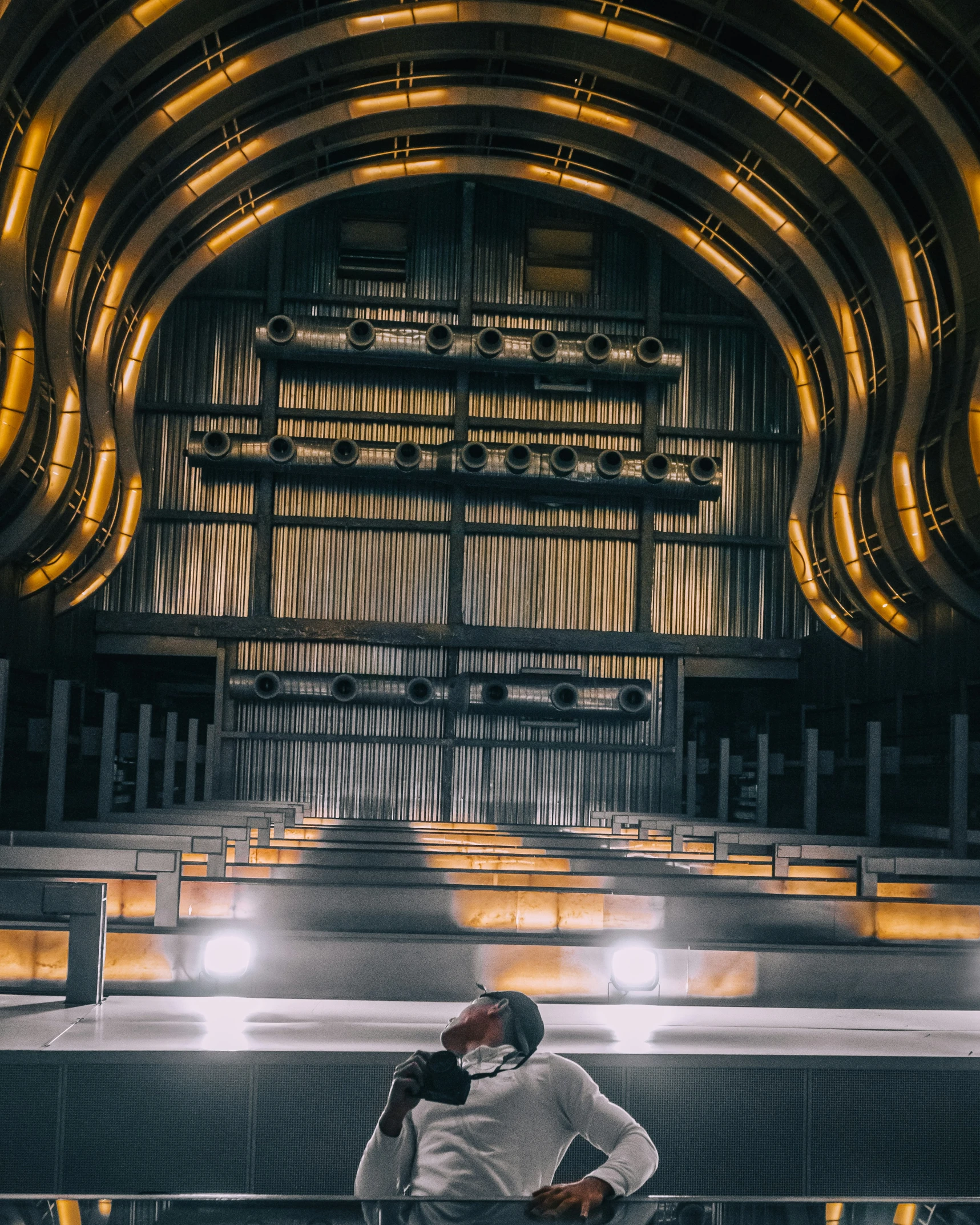 a man sits alone in front of an illuminated auditorium