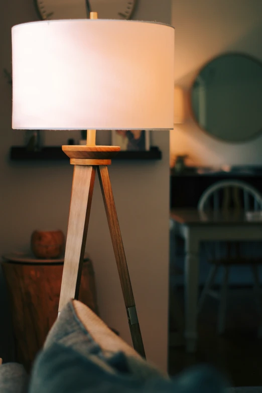 the floor lamp is on top of a tripod stand