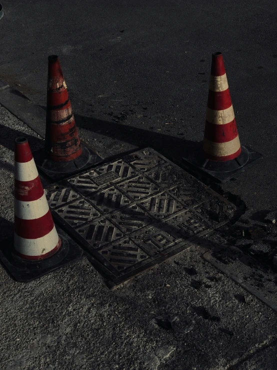 there is a street sign between two road cones