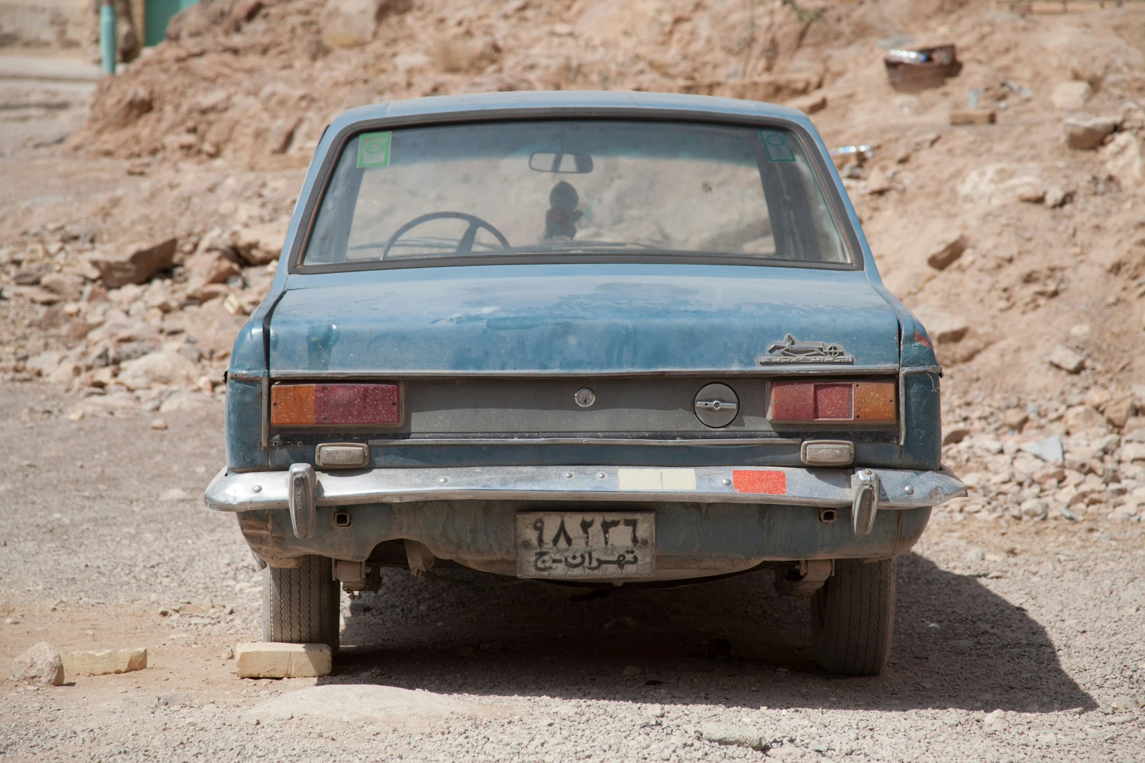 there is an old car in the dirt