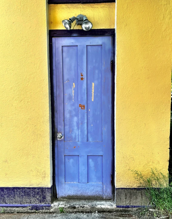 a blue doorway between two yellow walls