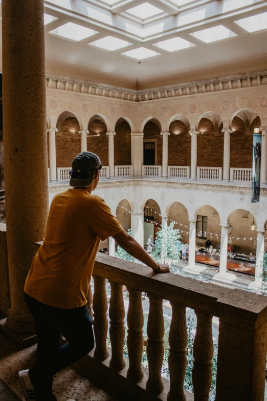 the man is leaning over the railing of the balcony