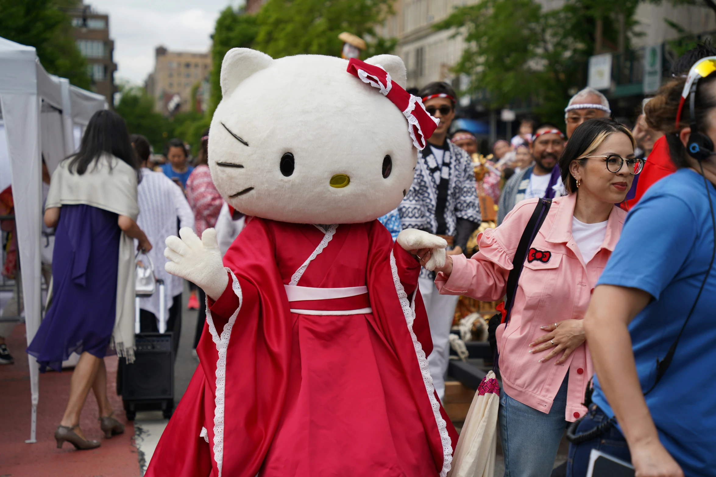 a large white hello kitty stuffed animal standing in front of a crowd