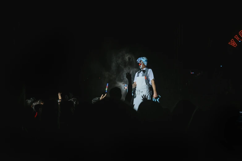 a man standing in the dark holding onto a microphone