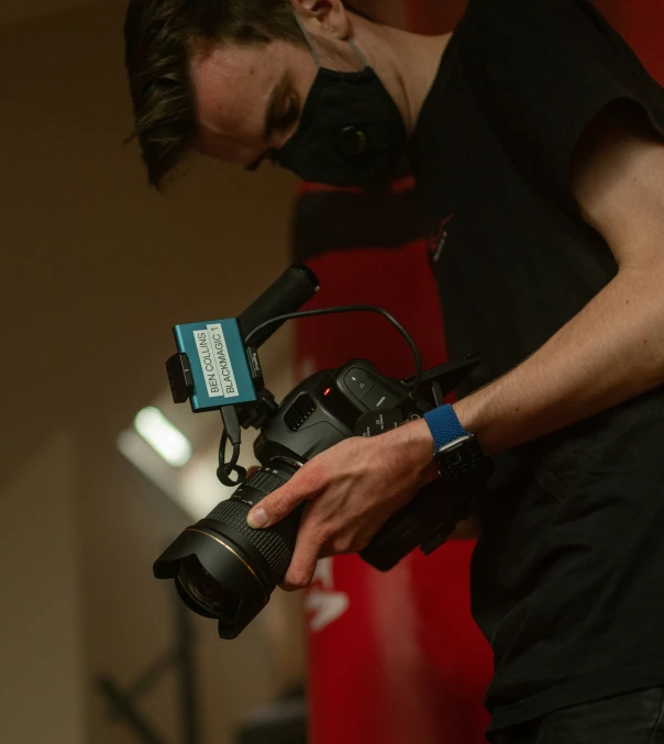 a woman holding a camera and a phone with her hands