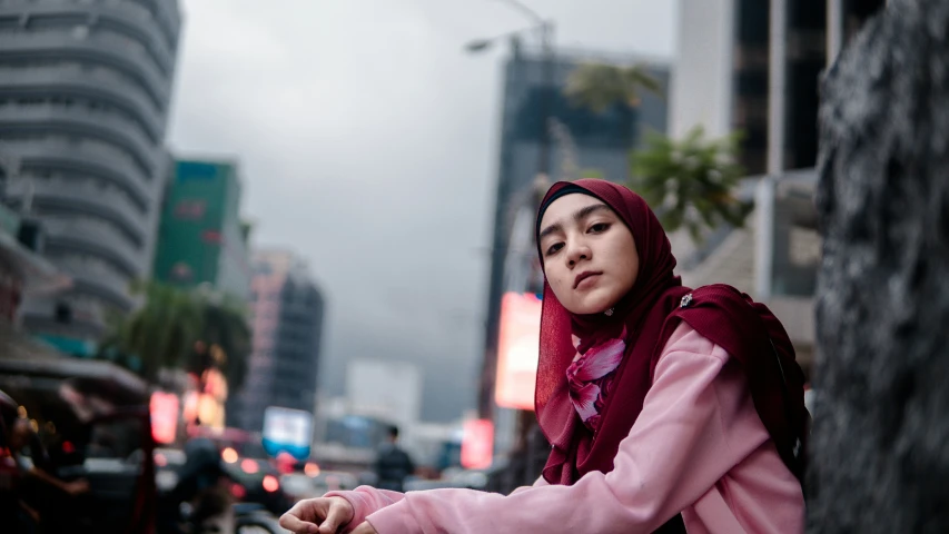 a girl wearing a red head scarf looking off into the distance