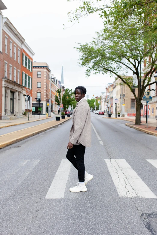 a man standing on the cross walk in an empty street