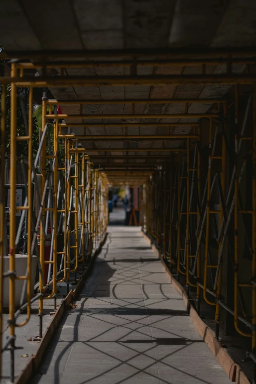 a row of yellow railings down a walkway