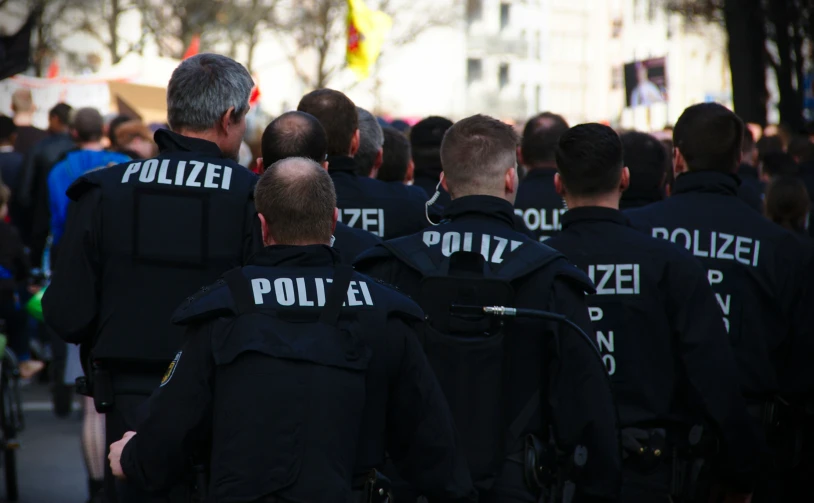 several police officers walking side by side down a street