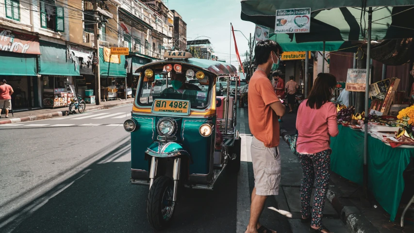 a woman and man looking at a motorcycle parked in the street