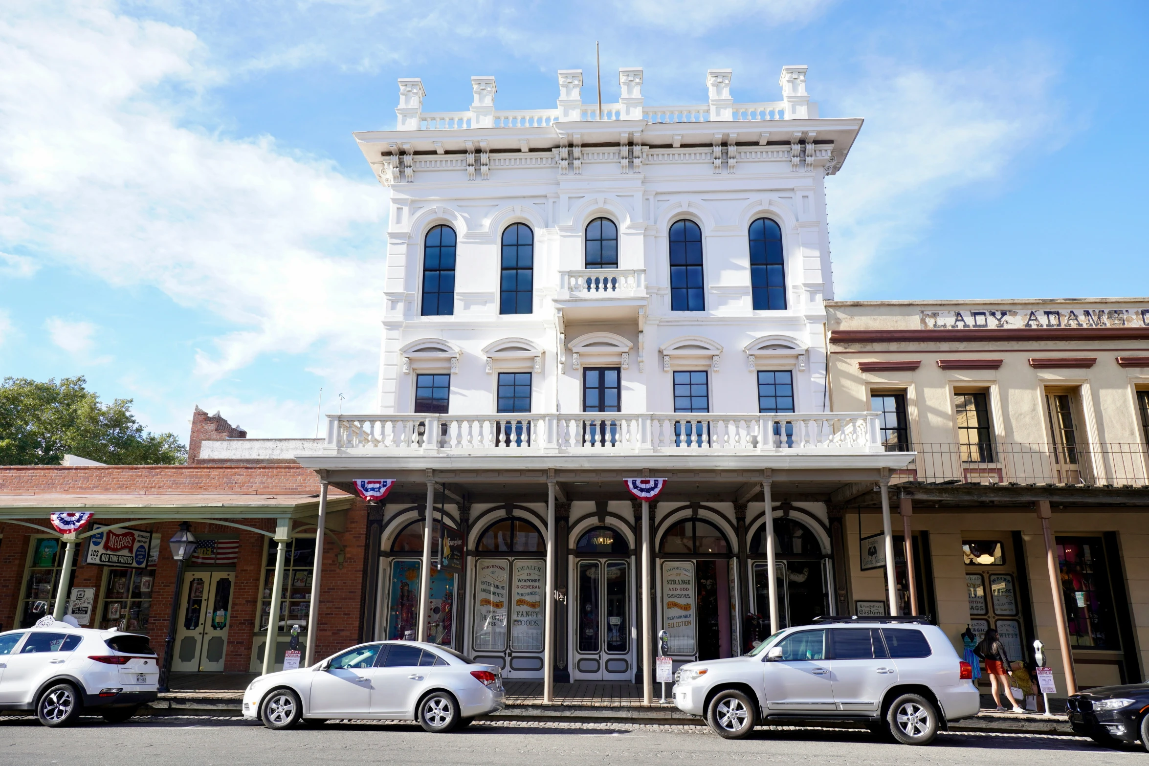 two cars parked on the street in front of an old building