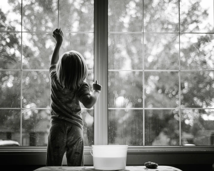 a child reaching up to reach the window sill