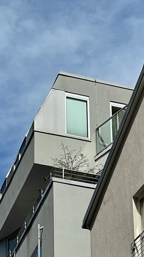 an apartment building with balconies and the sky above