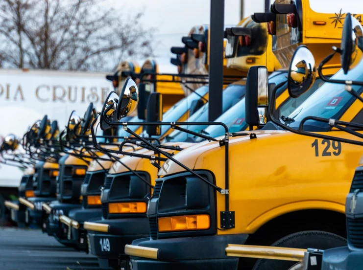 a row of school buses lined up in a parking lot