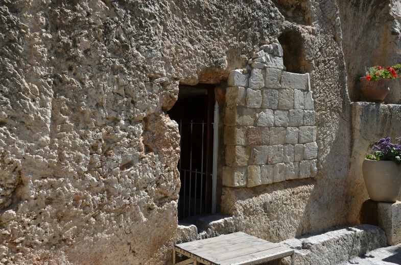 a bench sitting in front of a rock wall