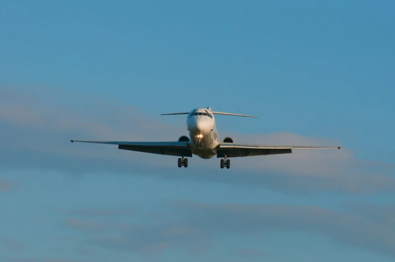 a jet airplane in the air, with its landing gear down