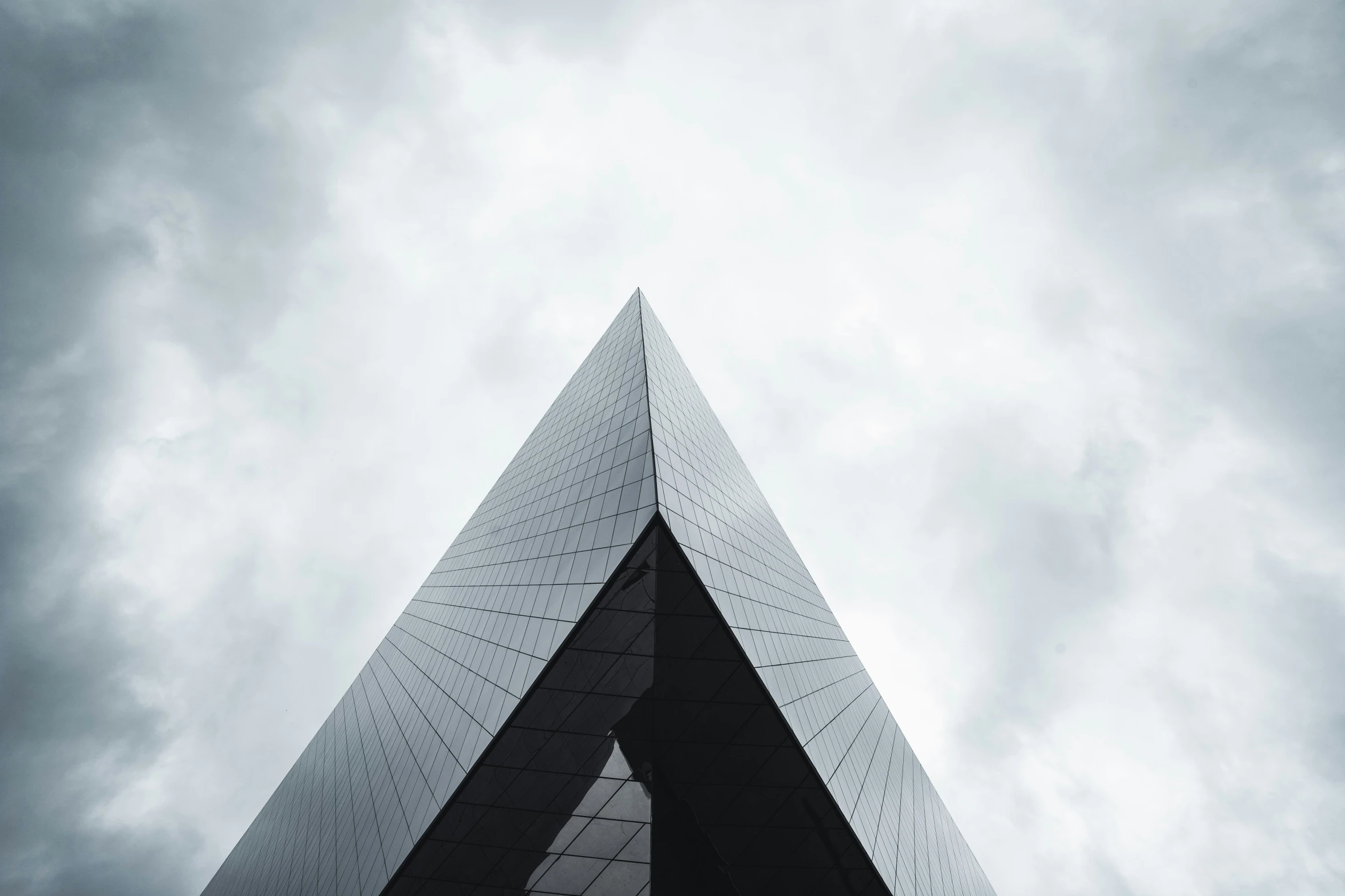 looking up at a black triangular shaped building