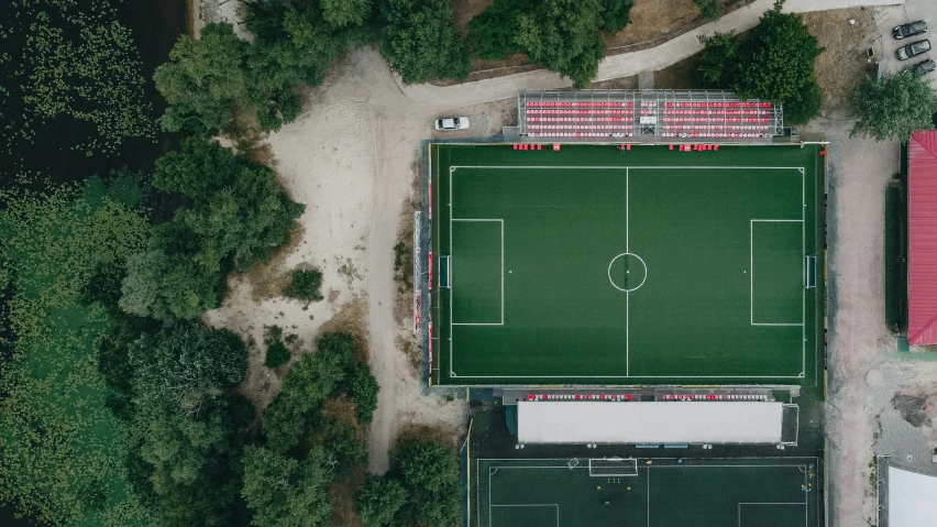 an overhead view of a soccer field and the surrounding green areas