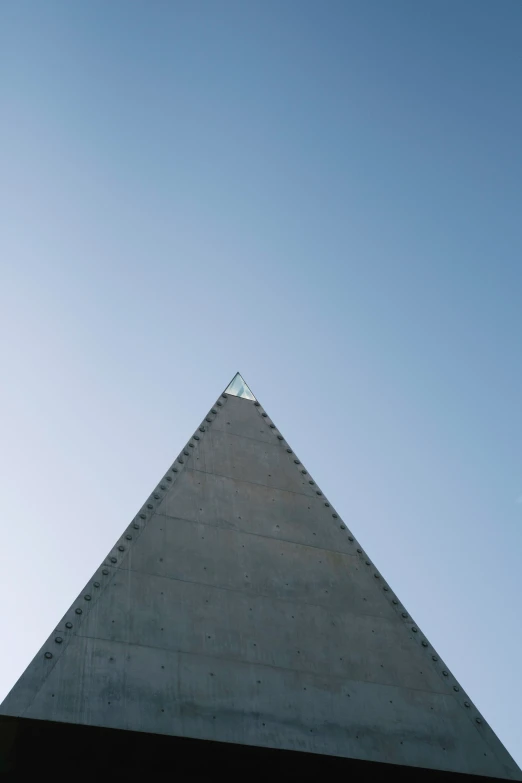 a plane flies over a concrete triangular structure