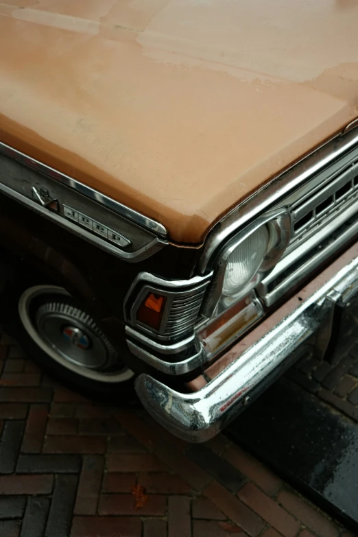 an old car parked in a driveway with rust