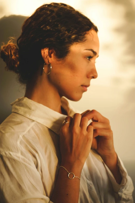 a beautiful young woman wearing a gold bang ear