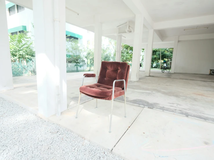 a chair sits on the concrete under a building