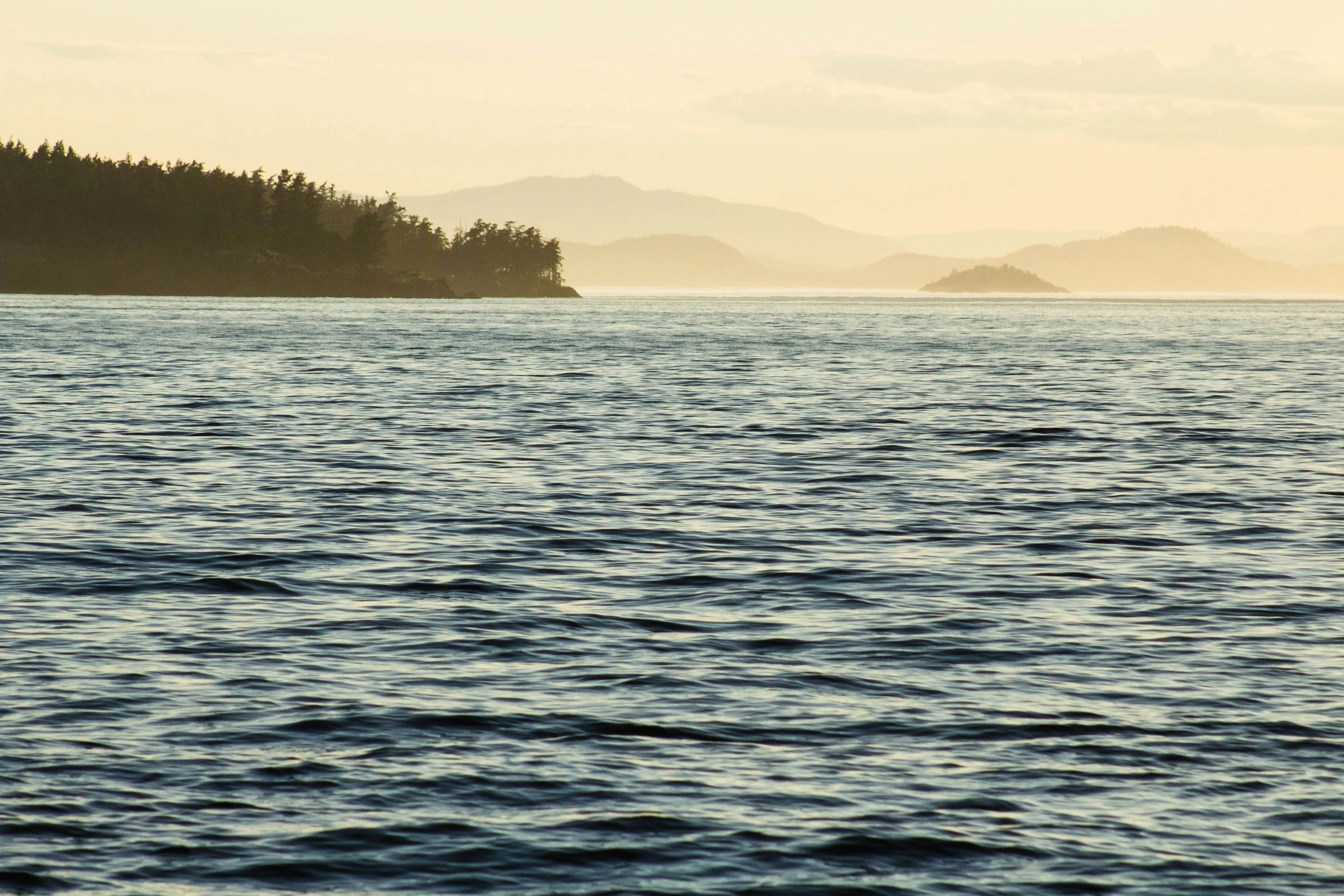 an island in the distance sits on a body of water