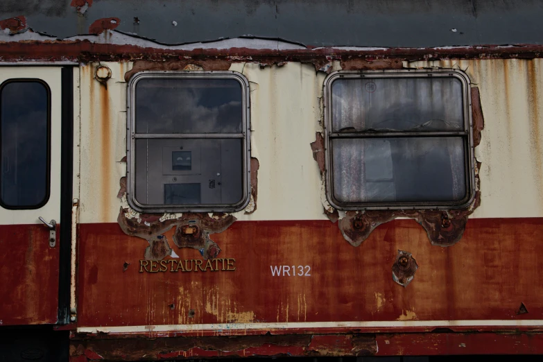 a rusted, crumbling train is sitting on the tracks