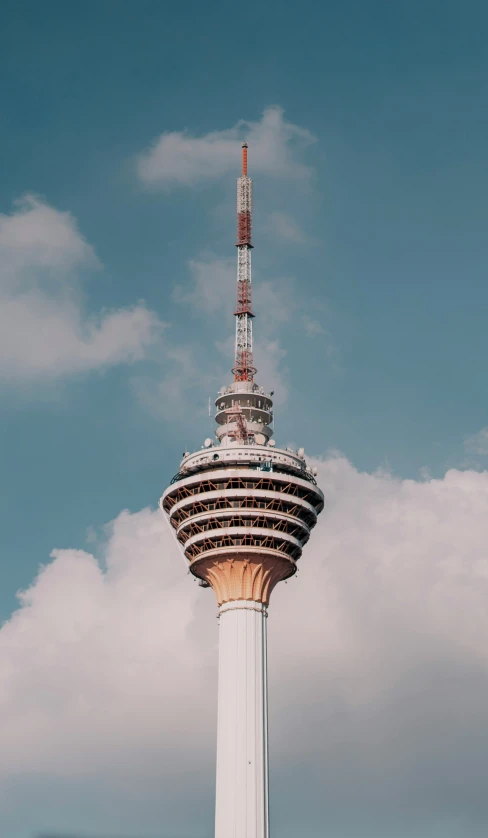 a very tall building that has a red and white spire