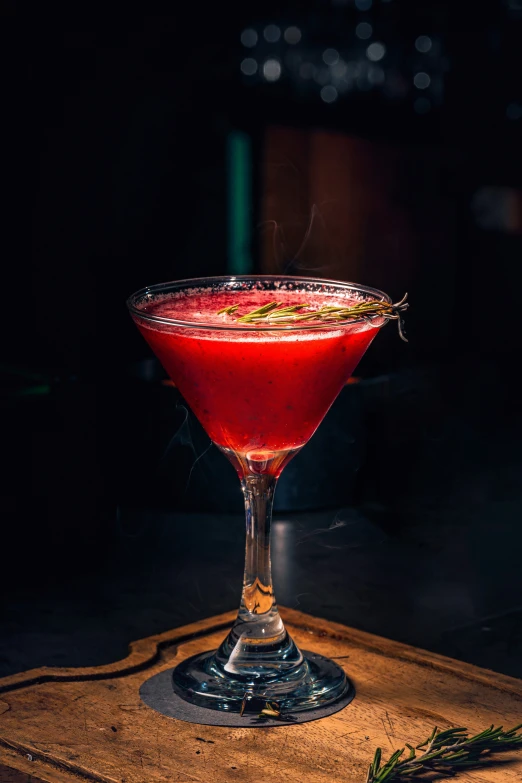 a cocktail sitting in a wine glass on top of a table