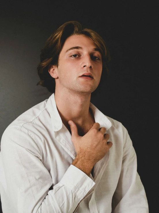 a man is posing with his hand on his neck