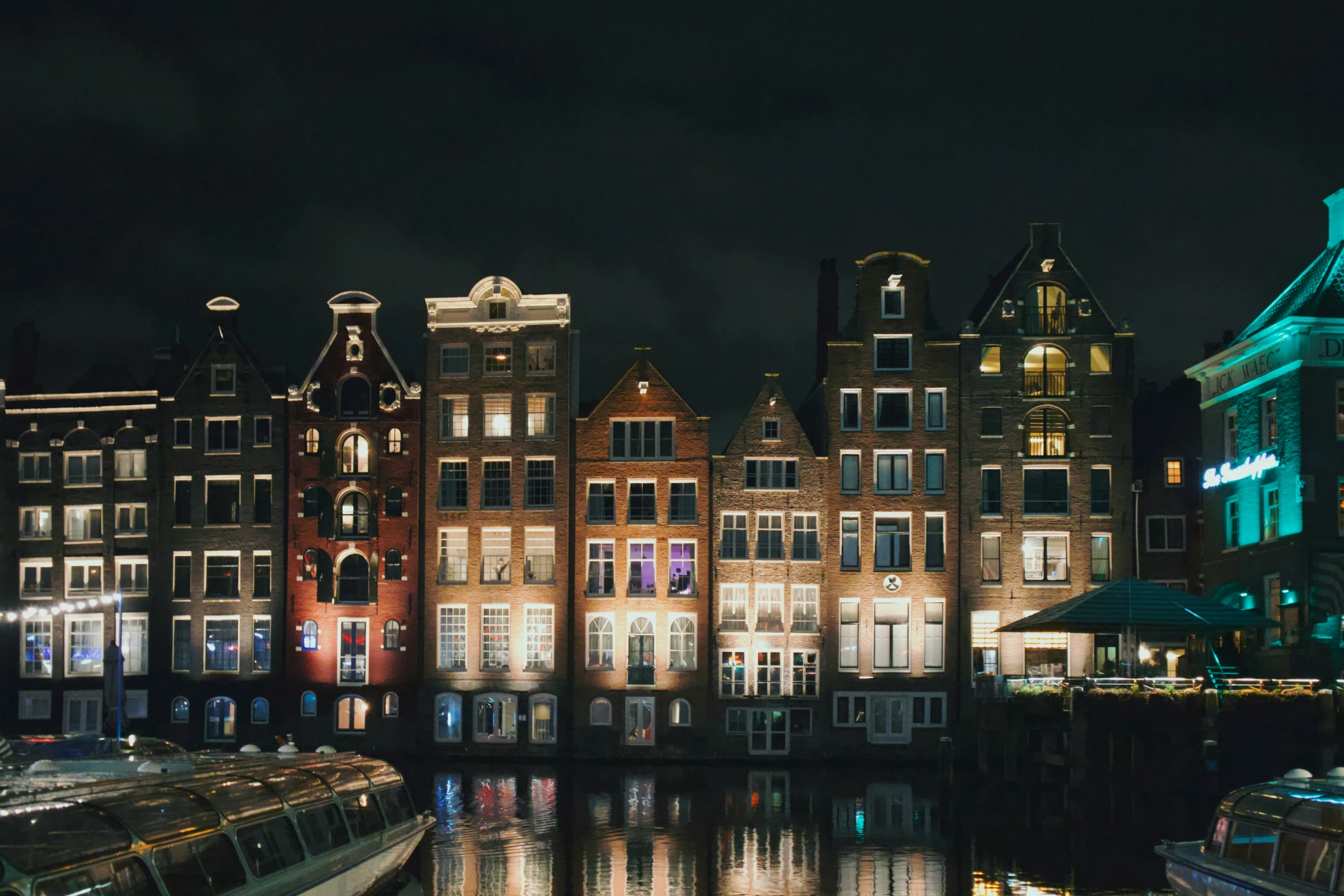 a nighttime scene of boats and buildings along the water