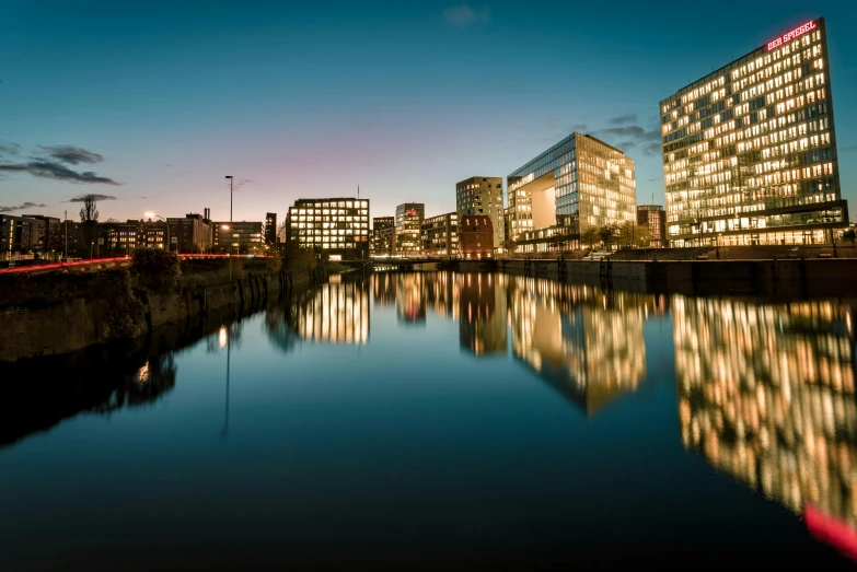 city buildings line the river in the evening