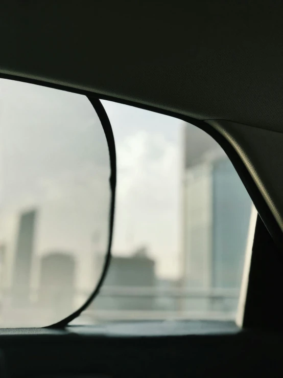 the side view mirror of a vehicle with cityscape in the background