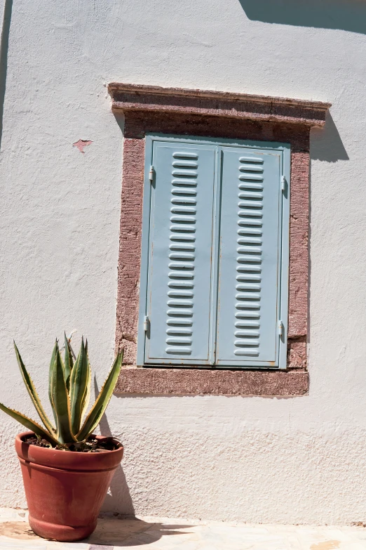 the blue window shutters are on the side of a building