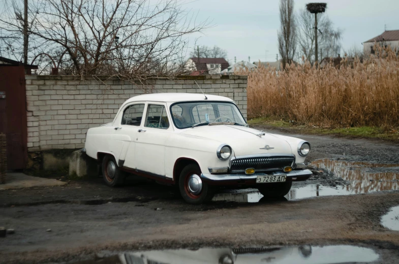 an old car sitting on the side of a road