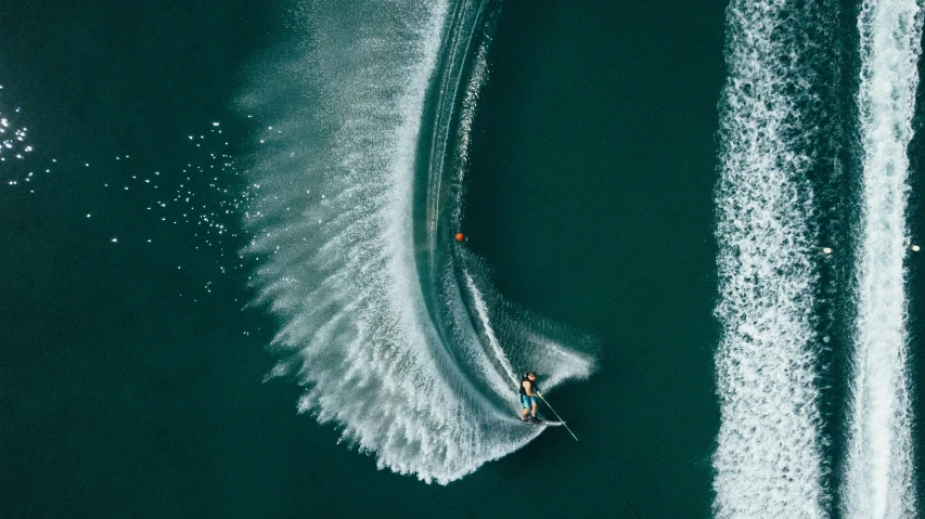 a man surfing on the ocean in a wake boat
